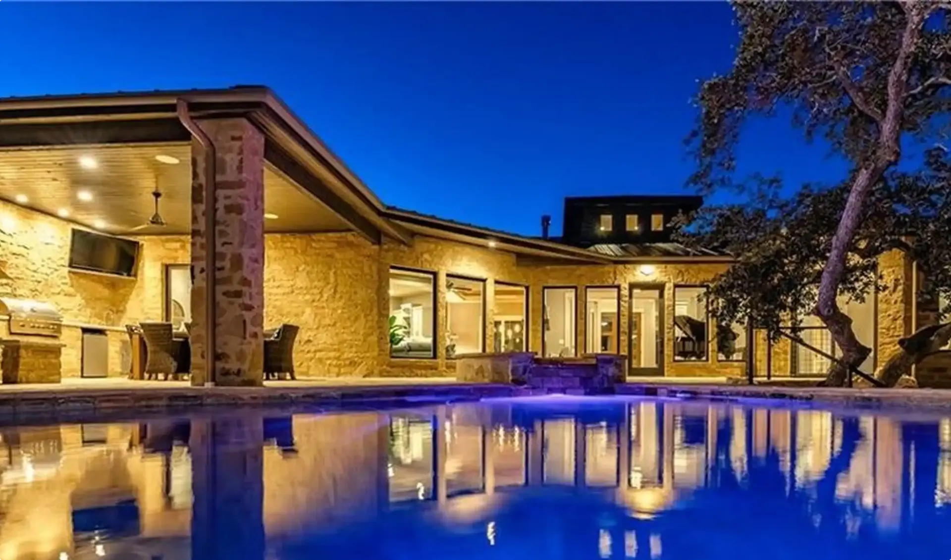 Your Guide for How to Finance A Pool 2 Stunning pool with additional lighting and an outdoor kitchen.