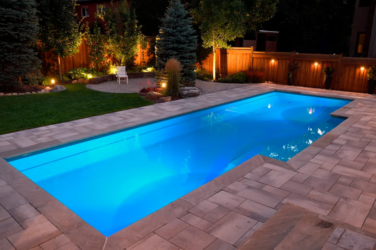 Pool Deck Ideas That Transform Your Texas Backyard 1 Backyard pool with wood deck, lounge chairs, and lush garden landscaping