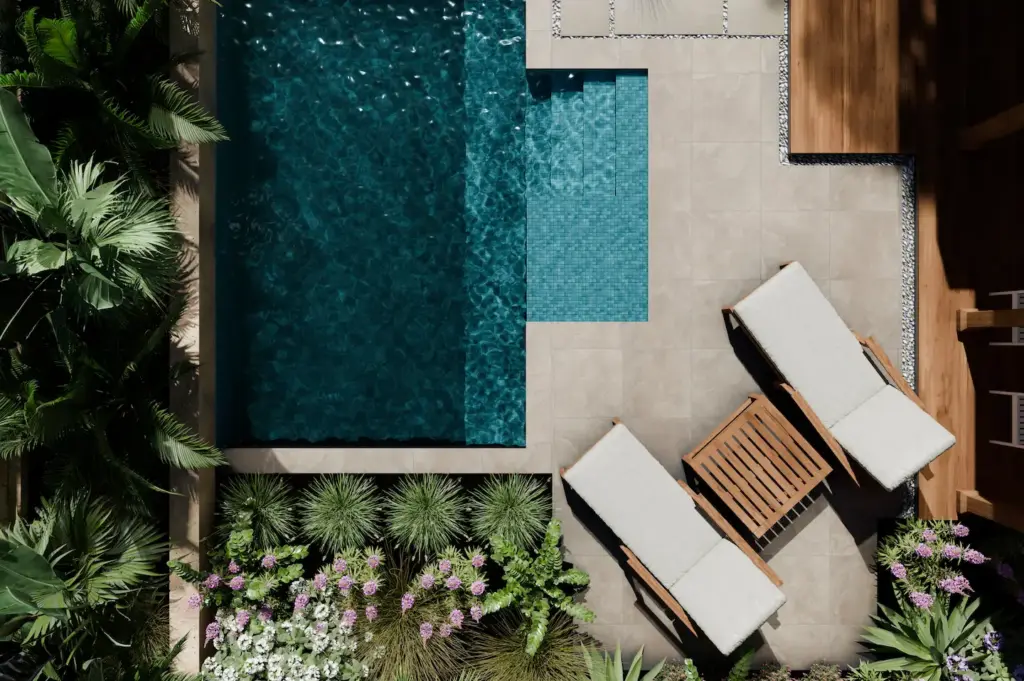 View of an energy efficient backyard pool with a raised spa, teak lounge chairs, and lush landscaping 